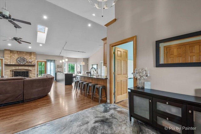 3609 Sagebrush Ct, Johnsburg, IL 60051 - living area featuring ceiling fan, wood finished floors, a skylight, vaulted ceiling, and a large fireplace