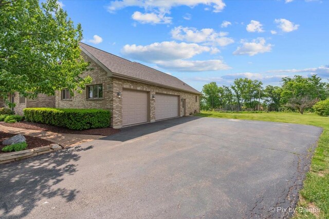 3609 Sagebrush Ct, Johnsburg, IL 60051 - view of property exterior with brick siding, driveway, a garage, a lawn, and a shingled roof