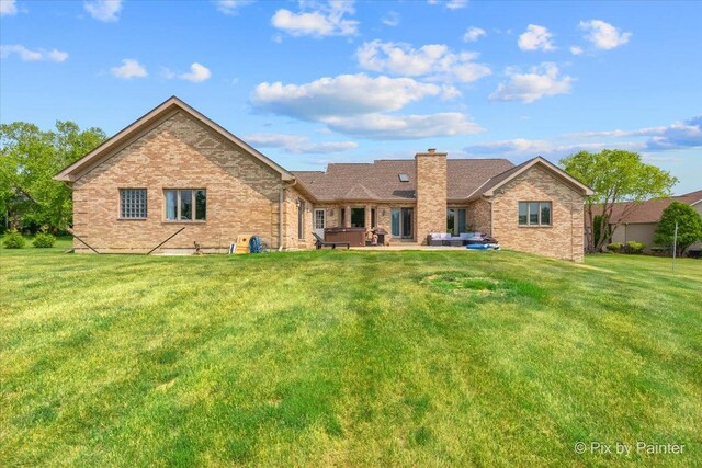 3609 Sagebrush Ct, Johnsburg, IL 60051 - view of front of property featuring a covered hot tub, brick siding, a front yard, a chimney, and a patio area
