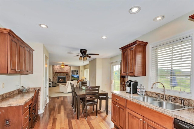 942 Meadowbrook Rd, Elwood, IL 60421 - kitchen with a sink, a fireplace, open floor plan, ceiling fan, and wood finished floors