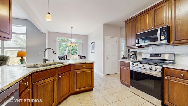 2217 Tyler Trl, Mchenry, IL 60051 - kitchen featuring black microwave, stainless steel gas range, a sink, decorative light fixtures, and brown cabinetry