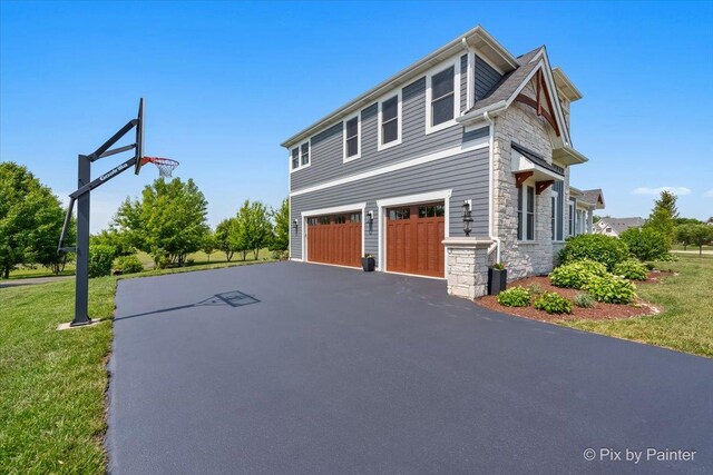 1044 Redbud Ln, Sugar Grove, IL 60554 - view of property exterior featuring stone siding, a lawn, an attached garage, and driveway