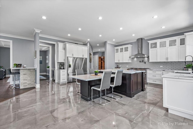 1044 Redbud Ln, Sugar Grove, IL 60554 - kitchen with appliances with stainless steel finishes, wall chimney range hood, crown molding, tasteful backsplash, and recessed lighting