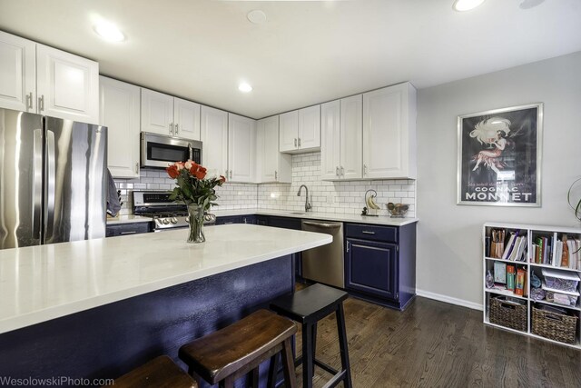 3315 N Racine Ave Unit E, Chicago, IL 60657 - kitchen with stainless steel appliances, a kitchen bar, white cabinetry, and recessed lighting