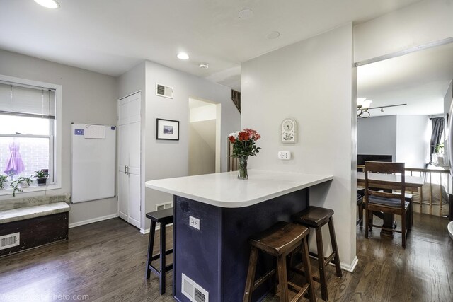 3315 N Racine Ave Unit E, Chicago, IL 60657 - kitchen with a breakfast bar, dark wood finished floors, light countertops, a peninsula, and recessed lighting
