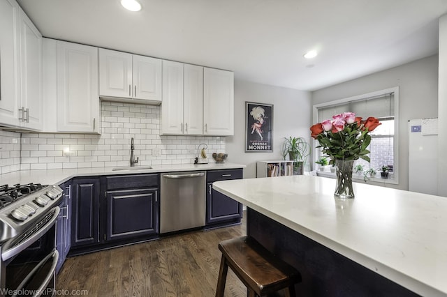 3315 N Racine Ave Unit E, Chicago, IL 60657 - kitchen featuring appliances with stainless steel finishes, white cabinets, backsplash, dark wood-style floors, and a kitchen bar