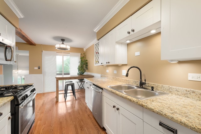 1355 Kingsbury Dr Unit 1, Hanover Park, IL 60133 - kitchen featuring appliances with stainless steel finishes, a sink, light wood-type flooring, white cabinets, and ornamental molding