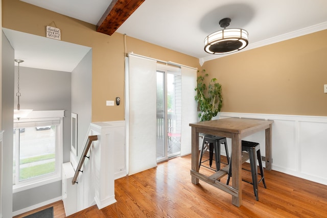 1355 Kingsbury Dr Unit 1, Hanover Park, IL 60133 - dining area with light wood finished floors, a wainscoted wall, beam ceiling, and a decorative wall