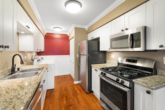 1355 Kingsbury Dr Unit 1, Hanover Park, IL 60133 - kitchen featuring stainless steel appliances, a sink, separate washer and dryer, crown molding, and wood finished floors