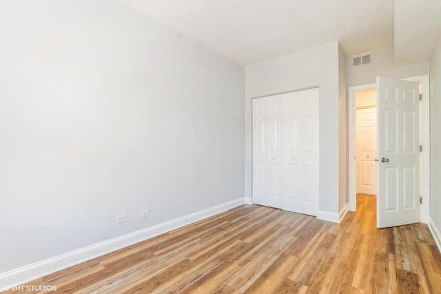 7363 N Damen Ave Unit 302, Chicago, IL 60645 - unfurnished bedroom featuring light wood-style floors, baseboards, and a closet