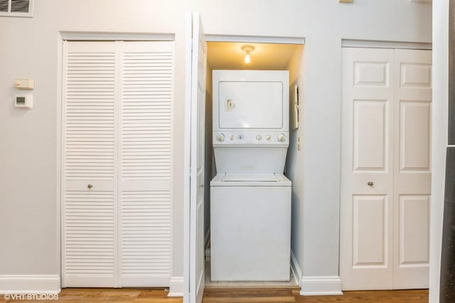 7363 N Damen Ave Unit 302, Chicago, IL 60645 - laundry room with estacked washer and dryer, wood finished floors, and baseboards