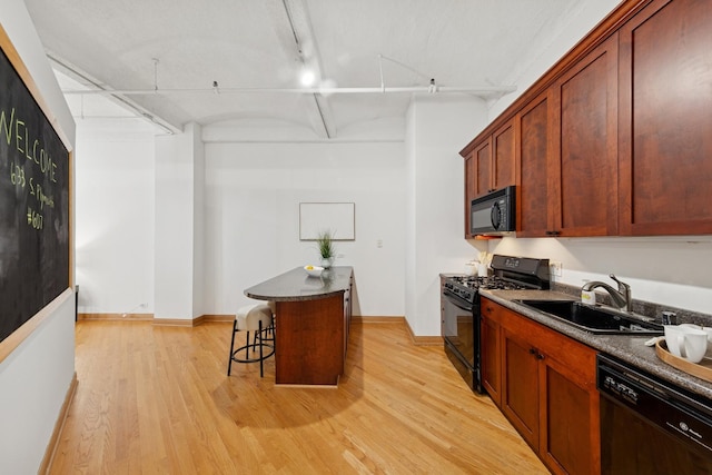 633 S Plymouth Ct Unit 607, Chicago, IL 60605 - kitchen featuring black appliances, a sink, light wood-type flooring, dark countertops, and a breakfast bar