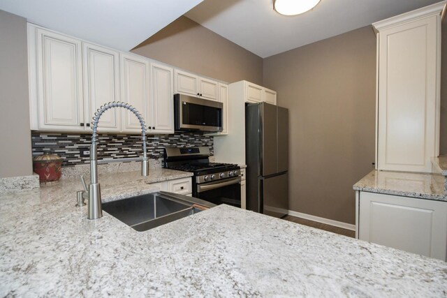 218 Partridge Ct, Algonquin, IL 60102 - kitchen featuring appliances with stainless steel finishes, tasteful backsplash, light stone counters, and white cabinetry