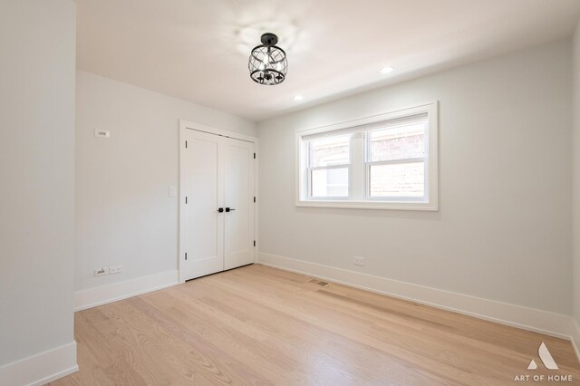 6012 S Narragansett Ave, Chicago, IL 60638 - unfurnished bedroom with light wood finished floors, baseboards, recessed lighting, and a closet