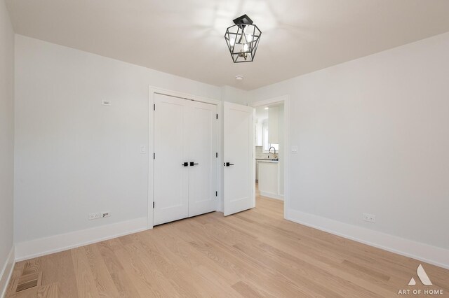 6012 S Narragansett Ave, Chicago, IL 60638 - unfurnished bedroom with light wood-style floors, baseboards, and a closet