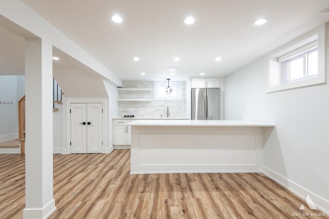 6012 S Narragansett Ave, Chicago, IL 60638 - kitchen with freestanding refrigerator, white cabinets, light countertops, a peninsula, and light wood finished floors