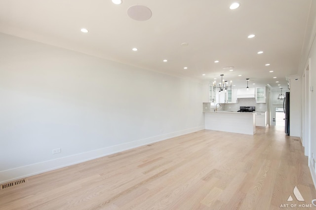 6012 S Narragansett Ave, Chicago, IL 60638 - unfurnished living room with recessed lighting, a sink, a chandelier, light wood-style floors, and baseboards