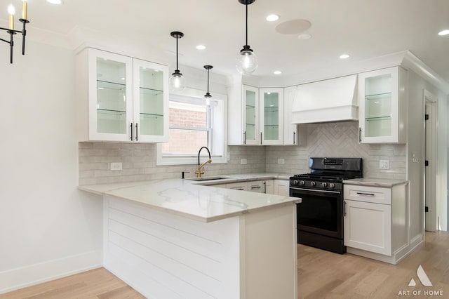 6012 S Narragansett Ave, Chicago, IL 60638 - kitchen with black gas range, a sink, premium range hood, light stone counters, and light wood finished floors
