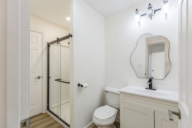 313 Grand Blvd, Loves Park, IL 61111 - bathroom with a shower stall, vanity, toilet, and wood finished floors