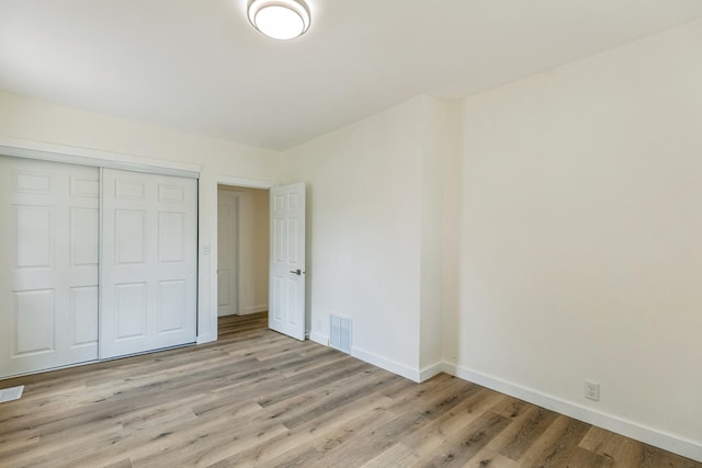 313 Grand Blvd, Loves Park, IL 61111 - unfurnished bedroom with baseboards, light wood-style floors, and a closet