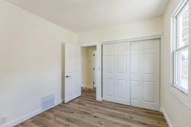 313 Grand Blvd, Loves Park, IL 61111 - unfurnished bedroom featuring wood finished floors, multiple windows, and baseboards