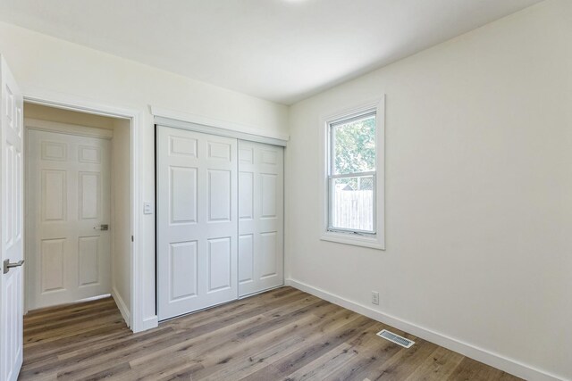 313 Grand Blvd, Loves Park, IL 61111 - unfurnished bedroom with baseboards, light wood-style floors, and a closet