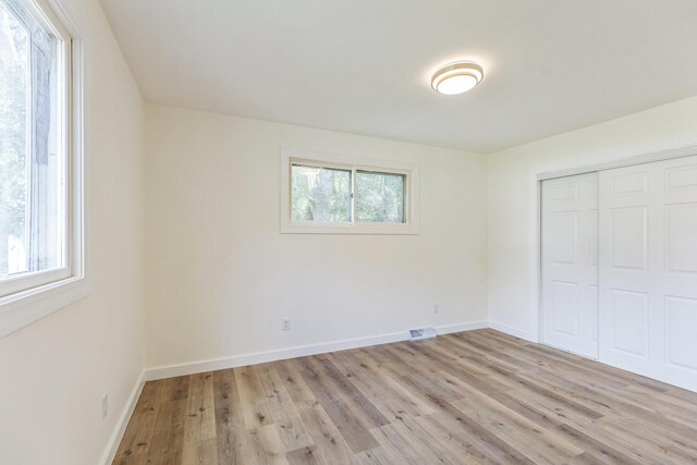 313 Grand Blvd, Loves Park, IL 61111 - unfurnished bedroom featuring light wood-style floors, a closet, and baseboards