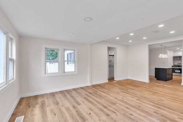 313 Grand Blvd, Loves Park, IL 61111 - unfurnished living room with light wood finished floors, baseboards, and recessed lighting