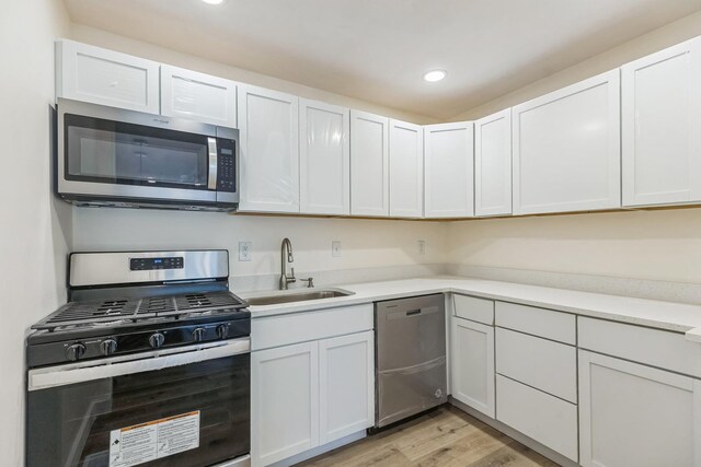 313 Grand Blvd, Loves Park, IL 61111 - kitchen featuring stainless steel appliances, a sink, light countertops, light wood-style flooring, and recessed lighting