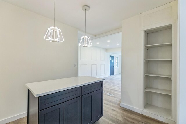 313 Grand Blvd, Loves Park, IL 61111 - kitchen with light wood-style floors, baseboards, light countertops, pendant lighting, and a center island
