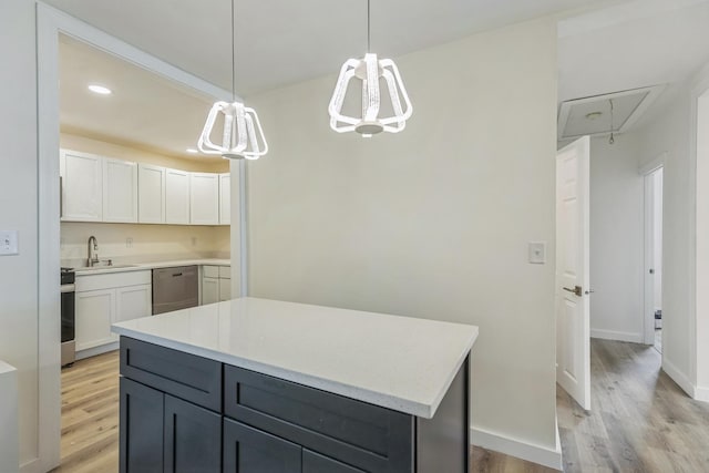 313 Grand Blvd, Loves Park, IL 61111 - kitchen with stainless steel appliances, a sink, light wood-type flooring, light countertops, and a center island