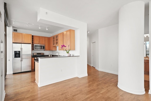 233 E 13th St Unit 601, Chicago, IL 60605 - kitchen featuring appliances with stainless steel finishes, glass insert cabinets, light wood-style flooring, a sink, and track lighting