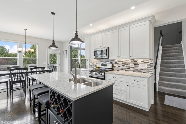 2758 Palm Springs Ln, Aurora, IL 60502 - kitchen featuring appliances with stainless steel finishes, a sink, tasteful backsplash, an island with sink, and plenty of natural light