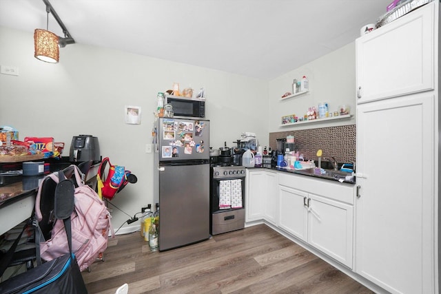 4854 W Addison St, Chicago, IL 60641 - kitchen with stainless steel appliances, light wood finished floors, white cabinets, dark countertops, and open shelves
