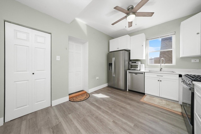 4854 W Addison St, Chicago, IL 60641 - kitchen featuring appliances with stainless steel finishes, a sink, light wood-style flooring, a ceiling fan, and white cabinets