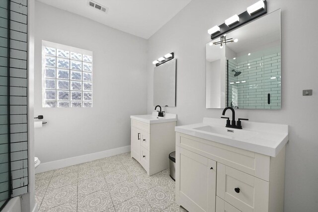 4854 W Addison St, Chicago, IL 60641 - full bathroom with a stall shower, two vanities, baseboards, and toilet