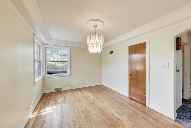 10117 Potter Rd, Des Plaines, IL 60016 - spare room featuring arched walkways, a chandelier, light wood-style floors, crown molding, and a tray ceiling