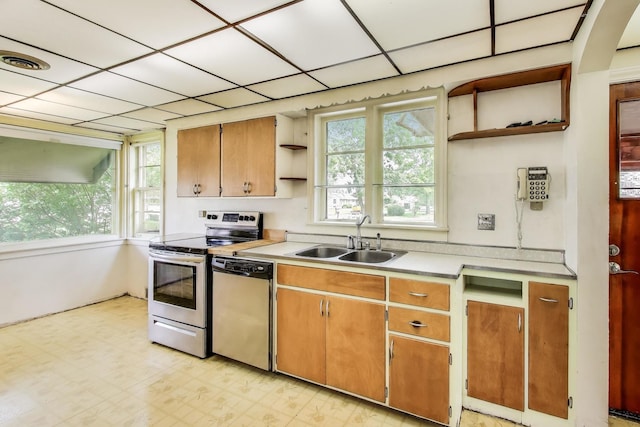 10117 Potter Rd, Des Plaines, IL 60016 - kitchen with open shelves, appliances with stainless steel finishes, a sink, light countertops, and light floors
