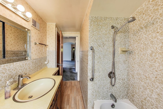 10117 Potter Rd, Des Plaines, IL 60016 - bathroom with wood finished floors, shower / bathtub combination, vanity, and wainscoting