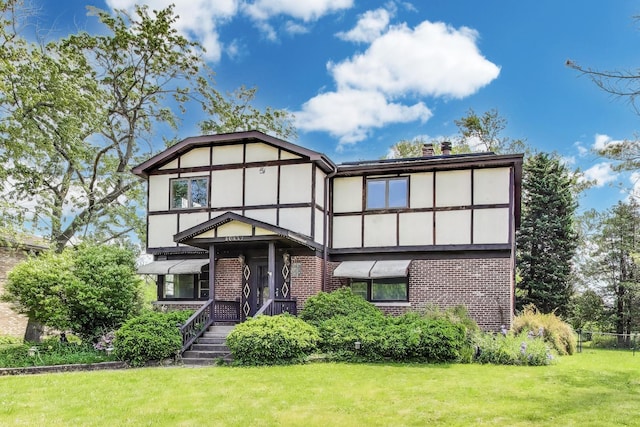 10117 Potter Rd, Des Plaines, IL 60016 - tudor house featuring brick siding, a front yard, stucco siding, and a chimney