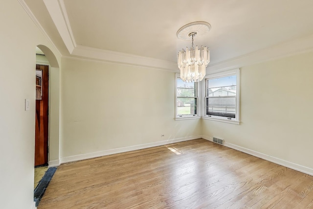 10117 Potter Rd, Des Plaines, IL 60016 - spare room featuring a chandelier, arched walkways, ornamental molding, light wood-style floors, and baseboards