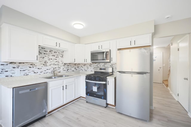 9002 N Clifton Ave, Niles, IL 60714 - kitchen with stainless steel appliances, a sink, light wood-style floors, and white cabinets