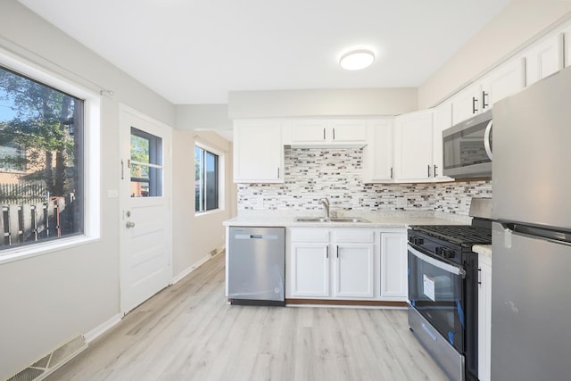 9002 N Clifton Ave, Niles, IL 60714 - kitchen with appliances with stainless steel finishes, a sink, light countertops, and white cabinets