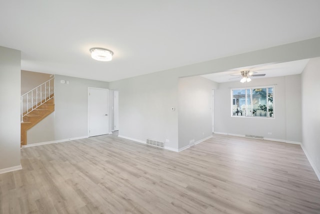 9002 N Clifton Ave, Niles, IL 60714 - empty room with stairway, light wood-style floors, a ceiling fan, and baseboards
