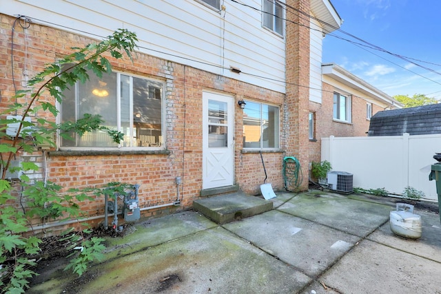 9002 N Clifton Ave, Niles, IL 60714 - view of exterior entry with brick siding, cooling unit, and a patio area