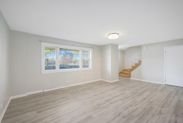 9002 N Clifton Ave, Niles, IL 60714 - spare room featuring baseboard heating, stairs, light wood-style floors, and baseboards