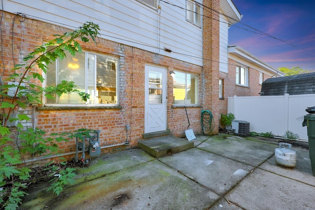 9002 N Clifton Ave, Niles, IL 60714 - entrance to property featuring brick siding, a patio, and cooling unit