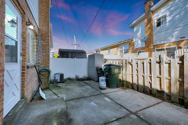 9002 N Clifton Ave, Niles, IL 60714 - patio terrace at dusk with a patio, a fenced backyard, and central AC unit