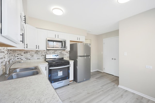 9002 N Clifton Ave, Niles, IL 60714 - kitchen featuring appliances with stainless steel finishes, a sink, backsplash, light countertops, and white cabinets