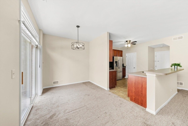 1133 Heron Cir, Joliet, IL 60431 - kitchen with stainless steel refrigerator with ice dispenser, brown cabinets, light carpet, light countertops, and baseboards